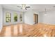 Spacious living room with hardwood floors, three windows, and a ceiling fan at 30103 Mossbank Dr, Wesley Chapel, FL 33543