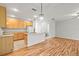 Open floor plan featuring wood-look floors connecting the kitchen, dining, and living area at 30103 Mossbank Dr, Wesley Chapel, FL 33543