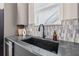 Close-up of the kitchen sink featuring black hardware, a stylish backsplash, and gray countertops at 3015 1St S Ave, St Petersburg, FL 33712