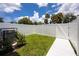 Private fenced-in backyard with lush grass, landscaping, and a modern A/C unit at 3402 E 28Th Ave # 4, Tampa, FL 33605