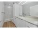 Modern bathroom with white cabinets, quartz countertop, a clear shower door, and wood-look floors at 3402 E 28Th Ave # 4, Tampa, FL 33605