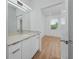 Modern bathroom with white cabinets, quartz countertop, a large mirror and wood-look floors at 3402 E 28Th Ave # 4, Tampa, FL 33605