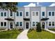 Modern townhome exterior with manicured lawn, tidy shrubs, gray and white facade, and black awning detail at 3402 E 28Th Ave # 4, Tampa, FL 33605