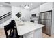 Modern kitchen featuring quartz counters, stainless appliances, a breakfast bar, and adjacent staircase and living area at 3402 E 28Th Ave # 4, Tampa, FL 33605