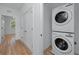 Hallway with a modern, stacked, front-load washer and dryer and wood-look floors at 3402 E 28Th Ave # 4, Tampa, FL 33605