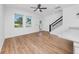 Sunlit living room featuring hardwood floors, staircase, and large windows with neighborhood views at 3402 E 28Th Ave # 4, Tampa, FL 33605