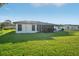 Back of the home features a lush, green lawn and a screened-in patio at 4065 38Th S St, St Petersburg, FL 33711