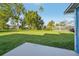 Large backyard features green grass and mature trees under a blue sky at 4065 38Th S St, St Petersburg, FL 33711