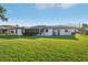 Spacious backyard with lush grass, and the back of the house with screened in porch at 4065 38Th S St, St Petersburg, FL 33711