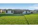 View of back of the home features a large, well-maintained lawn and a screened lanai at 4065 38Th S St, St Petersburg, FL 33711
