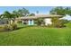 Well-maintained home showcasing lush green lawn and a bright blue front door at 4065 38Th S St, St Petersburg, FL 33711