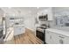 Well-lit kitchen with stainless steel appliances, white cabinets, and modern countertops at 4065 38Th S St, St Petersburg, FL 33711