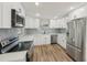 Well-lit kitchen featuring white cabinets, stainless steel appliances, and a stylish backsplash at 4065 38Th S St, St Petersburg, FL 33711