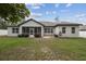 Exterior view of the backyard, showcasing a covered patio and green lawn at 4307 Dristol Ave, Spring Hill, FL 34609