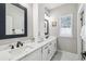 Bathroom with dual sinks, framed mirrors, white cabinets, and great natural light at 4307 Dristol Ave, Spring Hill, FL 34609
