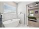 Elegant bathroom with a standalone tub, marble wall accent, and modern fixtures at 4307 Dristol Ave, Spring Hill, FL 34609