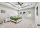 Bright bedroom with a tray ceiling, a ceiling fan, and a stylish bed with a green blanket at 4307 Dristol Ave, Spring Hill, FL 34609