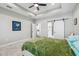 Another view of the bedroom, offering tray ceilings, fan, slider door to bathroom, and decorative bed frame at 4307 Dristol Ave, Spring Hill, FL 34609