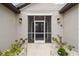 Close up of the home's screened entryway with decorative lanterns and a well kept garden at 4307 Dristol Ave, Spring Hill, FL 34609
