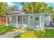 Charming home featuring a quaint front porch, seating area, and fresh exterior paint at 4803 N 9Th St, Tampa, FL 33603