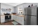 Well-lit kitchen with butcher block countertops, stainless steel appliances, and white cabinetry for a modern feel at 4803 N 9Th St, Tampa, FL 33603