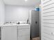 Clean laundry room with washer, dryer, storage cabinet, and white-painted walls at 4803 N 9Th St, Tampa, FL 33603