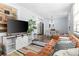 Inviting living room featuring a plush leather sofa, stylish TV console, and a view into the bright kitchen at 4803 N 9Th St, Tampa, FL 33603