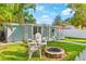 Backyard featuring a white picket fence, stone firepit, two chairs, and sidewalk to the front porch at 4803 N 9Th St, Tampa, FL 33603
