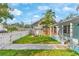Backyard featuring a white picket fence, stone firepit, two chairs, and sidewalk to the front porch at 4803 N 9Th St, Tampa, FL 33603