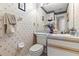 Quaint half bath with floral wallpaper, updated fixtures, vanity, and toilet at 5167 Sterling Manor Dr, Tampa, FL 33647