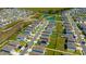 An aerial view of a community highlighting the well-maintained lawns and neighborhood pond at 5758 Hollingworth Trl, Wesley Chapel, FL 33545