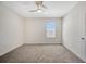 Empty bedroom with neutral carpeting, a window for natural light, and ceiling fan at 5758 Hollingworth Trl, Wesley Chapel, FL 33545