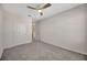A view of a bedroom with a ceiling fan and a glimpse into the hallway at 5758 Hollingworth Trl, Wesley Chapel, FL 33545
