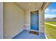 Cozy front porch with a blue front door, concrete flooring, and painted walls at 5758 Hollingworth Trl, Wesley Chapel, FL 33545