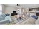 Spacious living room with modern furniture, ceiling fan and access to kitchen at 5758 Hollingworth Trl, Wesley Chapel, FL 33545