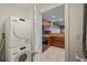Laundry machines next to a kitchen featuring stainless steel appliances and wood cabinetry at 628 Cleveland St # 1208, Clearwater, FL 33755