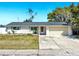 Charming single-story home features a well-manicured lawn, paved driveway, and a welcoming red door at 7205 Mayfield Dr, Port Richey, FL 34668