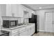 Bright kitchen with white cabinets, granite counters and stainless steel appliances at 7205 Mayfield Dr, Port Richey, FL 34668