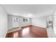 Well-lit living room featuring hardwood floors, an inviting door, and fresh paint at 7205 Mayfield Dr, Port Richey, FL 34668