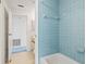 Bathroom with blue tiled shower/tub combination with a vanity visible through the doorway at 770 Arthurs Ct, Tarpon Springs, FL 34689