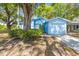 Attractive single-story blue home featuring well-maintained landscaping and an attached garage at 770 Arthurs Ct, Tarpon Springs, FL 34689