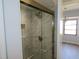 Updated bathroom features a glass enclosed shower with marble tiling and a built-in shower niche at 807 Nectar Rd, Venice, FL 34293