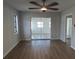 Empty bedroom with ceiling fan, wood floors and access to the living room at 807 Nectar Rd, Venice, FL 34293