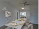 Dining room with a marble table set for six, a modern ceiling fan, and wood laminate flooring at 807 Nectar Rd, Venice, FL 34293
