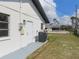 Home exterior featuring back door, HVAC, and a view of the grass backyard at 807 Nectar Rd, Venice, FL 34293