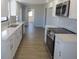 Modern kitchen features white cabinetry, stainless appliances, quartz counters, and wood-look flooring at 807 Nectar Rd, Venice, FL 34293