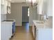 Bright kitchen featuring stainless appliances, white cabinets, subway tile backsplash, and wood-look flooring at 807 Nectar Rd, Venice, FL 34293
