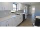 Modern kitchen featuring white cabinetry, stainless steel appliances, and wood laminate flooring at 807 Nectar Rd, Venice, FL 34293