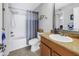 Bathroom with granite countertop, tiled floor, and shower/tub combination with gray curtains at 115 112Th Ne Ave # 310, St Petersburg, FL 33716