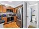 Kitchen with stainless appliances, wood cabinets, and black countertops, with a view to the bathroom at 115 112Th Ne Ave # 310, St Petersburg, FL 33716